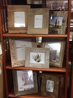 various pictures in frames with different designs on a shelf